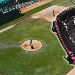 A wilson flash softball glove in front of a baseball field