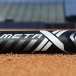 A Meta Fastpitch bat laying on the infield