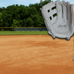 Softball gloves in front of a softball field.