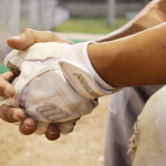 A man wearing softball batting gloves